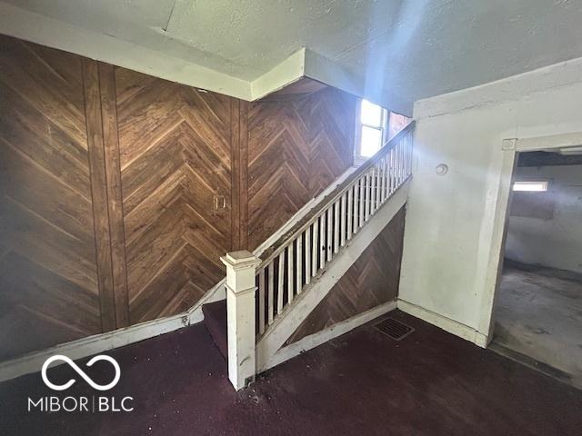 811 W 25th St, Indianapolis, IN 46208 - stairway with wood walls, baseboards, and a textured ceiling