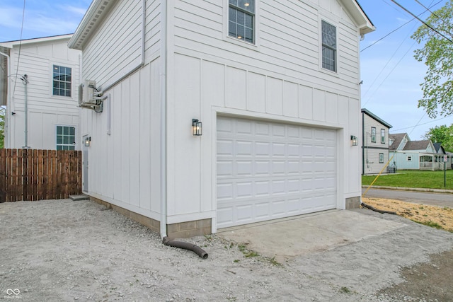 1825 E Maryland St, Indianapolis, IN 46201 - view of side of property with an attached garage, board and batten siding, and concrete driveway