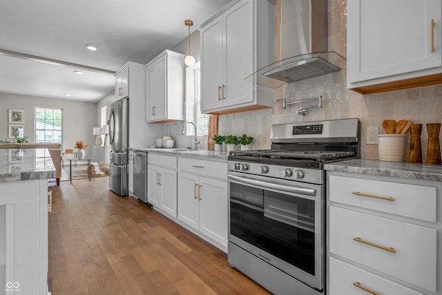 1825 E Maryland St, Indianapolis, IN 46201 - kitchen featuring appliances with stainless steel finishes, wall chimney range hood, wood finished floors, white cabinetry, and recessed lighting