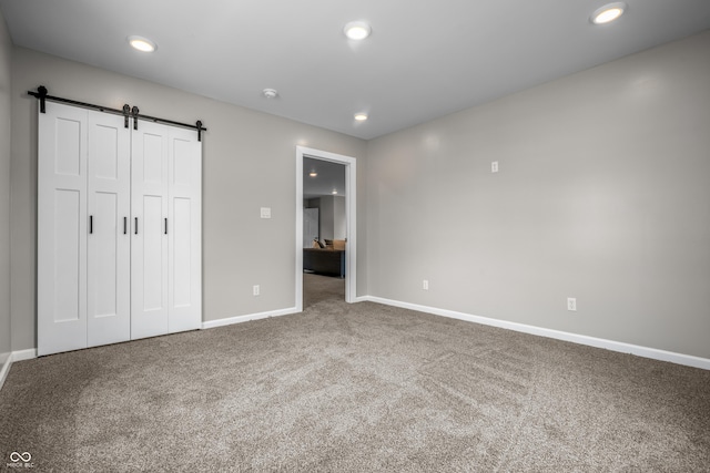 1825 E Maryland St, Indianapolis, IN 46201 - unfurnished bedroom with carpet, a barn door, baseboards, recessed lighting, and a closet