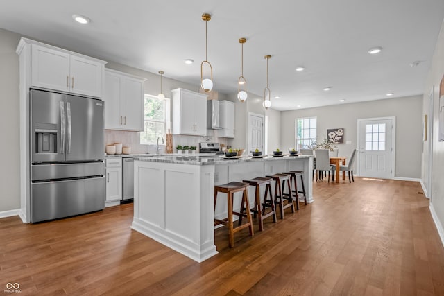 1825 E Maryland St, Indianapolis, IN 46201 - kitchen with stainless steel appliances, wood finished floors, a kitchen island with sink, white cabinetry, and recessed lighting