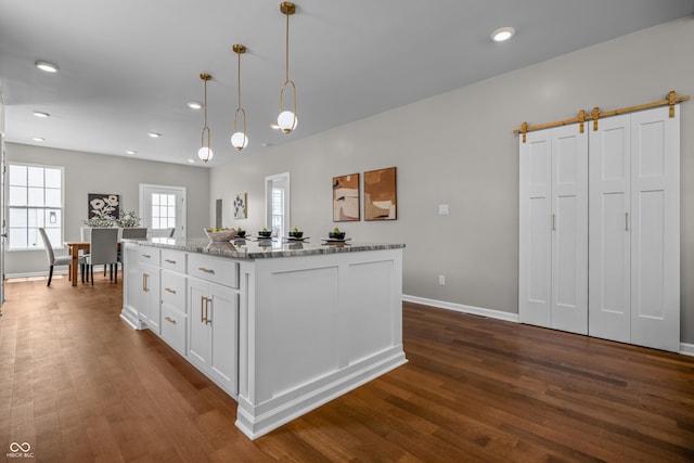 1825 E Maryland St, Indianapolis, IN 46201 - kitchen with white cabinets, dark wood-style flooring, hanging light fixtures, light stone countertops, and recessed lighting