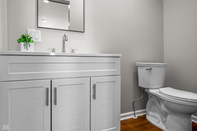 1825 E Maryland St, Indianapolis, IN 46201 - half bath featuring toilet, baseboards, wood finished floors, and vanity