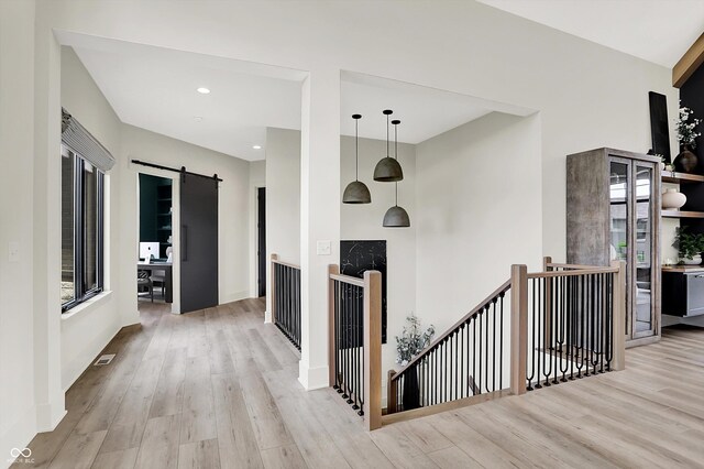 7116 Trail Ridge Ln, Indianapolis, IN 46259 - hall with an upstairs landing, wood finished floors, a barn door, recessed lighting, and healthy amount of natural light