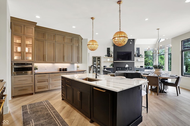 7116 Trail Ridge Ln, Indianapolis, IN 46259 - kitchen featuring a kitchen island with sink, recessed lighting, a chandelier, backsplash, and light stone countertops