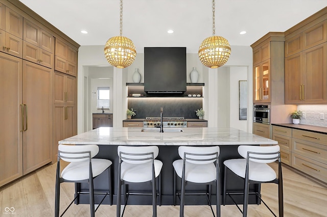 7116 Trail Ridge Ln, Indianapolis, IN 46259 - kitchen with a chandelier, range hood, backsplash, light stone counters, and light wood-style floors