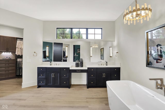 7116 Trail Ridge Ln, Indianapolis, IN 46259 - bathroom with a chandelier, double vanity, a freestanding bath, and wood finished floors