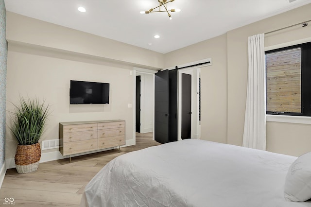 7116 Trail Ridge Ln, Indianapolis, IN 46259 - bedroom with light wood finished floors, a barn door, and recessed lighting