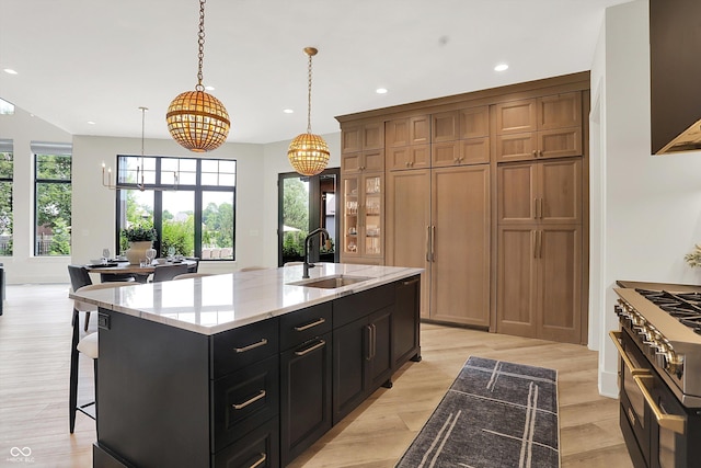 7116 Trail Ridge Ln, Indianapolis, IN 46259 - kitchen with stove, brown cabinets, a chandelier, recessed lighting, and an island with sink