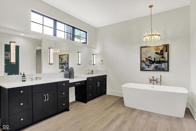 7116 Trail Ridge Ln, Indianapolis, IN 46259 - full bathroom with a chandelier, double vanity, a freestanding tub, wood finished floors, and a towering ceiling