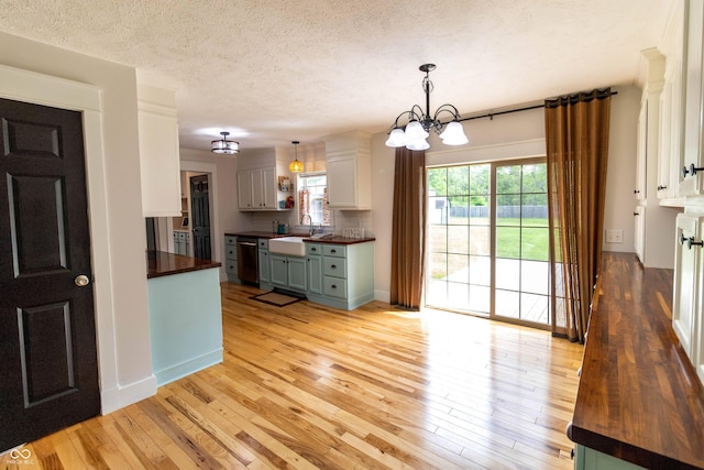 2935 N Grizzly Ln, Martinsville, IN 46151 - kitchen featuring butcher block countertops, stainless steel dishwasher, a chandelier, light wood-style floors, and a sink