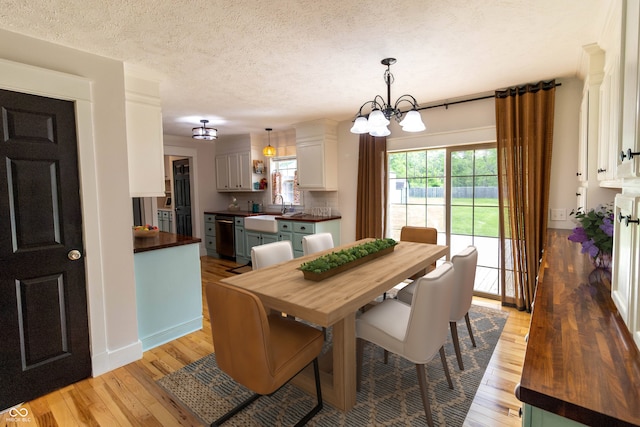 2935 N Grizzly Ln, Martinsville, IN 46151 - dining room with light wood finished floors, a chandelier, a textured ceiling, and baseboards