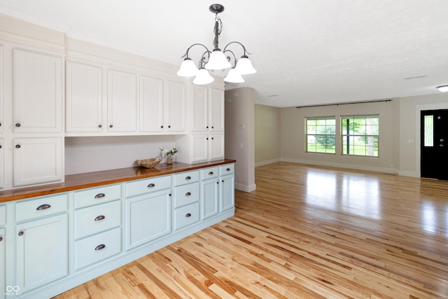 2935 N Grizzly Ln, Martinsville, IN 46151 - kitchen featuring butcher block countertops, open floor plan, a chandelier, baseboards, and light wood-type flooring