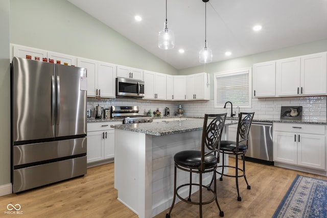 1959 Sophia Ln, Seymour, IN 47274 - kitchen with stainless steel appliances, tasteful backsplash, a kitchen bar, light stone counters, and white cabinets