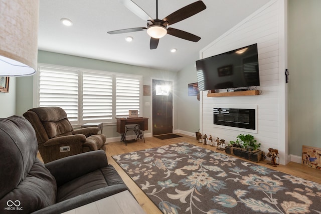 1959 Sophia Ln, Seymour, IN 47274 - living room featuring wood finished floors, a ceiling fan, lofted ceiling, a large fireplace, and recessed lighting