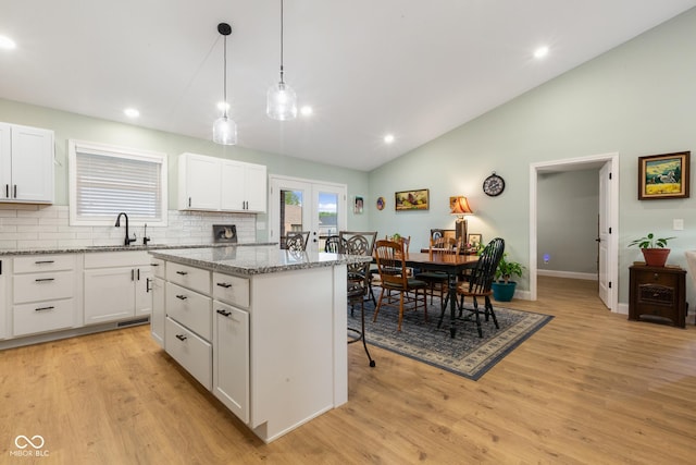 1959 Sophia Ln, Seymour, IN 47274 - kitchen featuring a sink, lofted ceiling, a kitchen island, light wood finished floors, and white cabinets