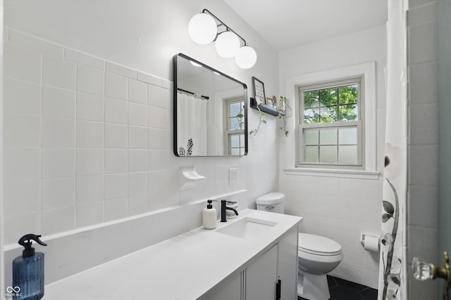 full bath with tile walls, toilet, vanity, tile patterned flooring, and a shower with curtain