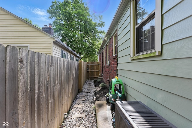 view of side of home with fence and brick siding