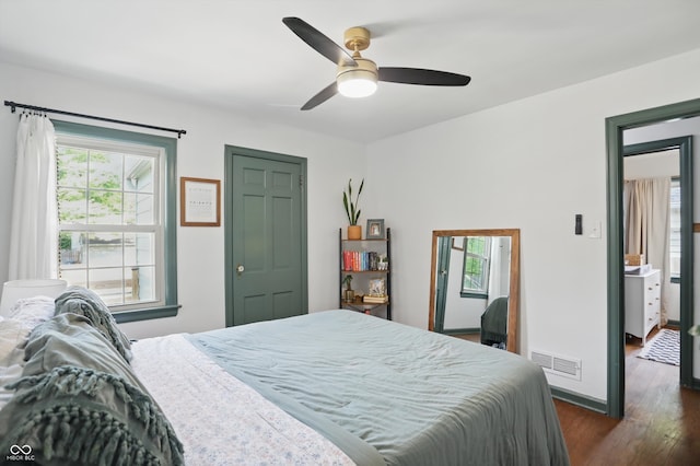 bedroom featuring dark wood finished floors, a ceiling fan, and baseboards