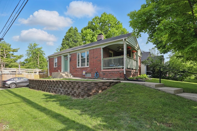 view of front of property with a ceiling fan, a chimney, and brick siding