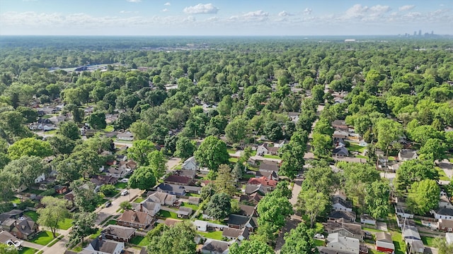 aerial overview of property's location featuring a forest and nearby suburban area
