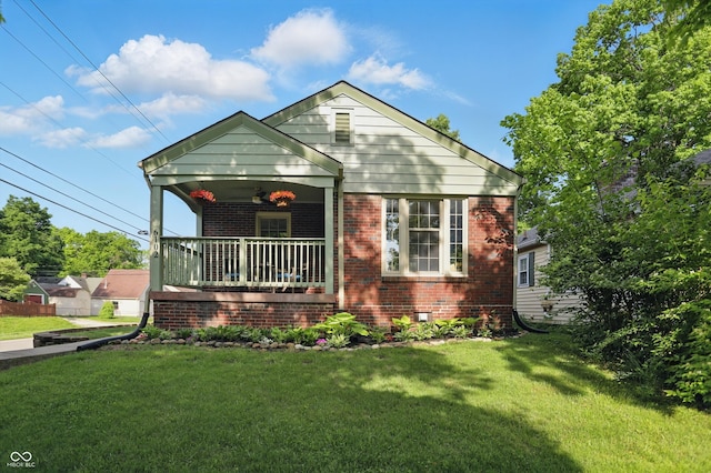 bungalow-style home featuring brick siding, a front lawn, a balcony, and crawl space