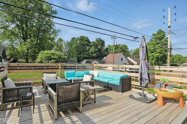deck with an outdoor hangout area, fence, and view of scattered trees