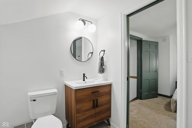 bathroom with vanity, toilet, vaulted ceiling, and baseboards