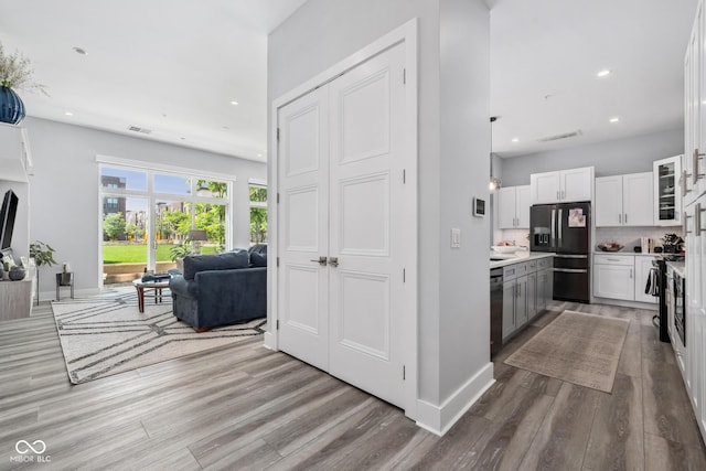 15 W Executive Dr Unit 101, Carmel, IN 46032 - kitchen with black refrigerator with ice dispenser, open floor plan, white cabinetry, wood finished floors, and dishwasher