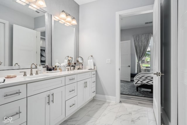 15 W Executive Dr Unit 101, Carmel, IN 46032 - ensuite bathroom with marble look tile flooring, double vanity, and baseboards