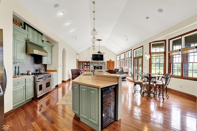 893 W 500 S, Anderson, IN 46013 - kitchen with green cabinetry, appliances with stainless steel finishes, beverage cooler, a stone fireplace, and arched walkways