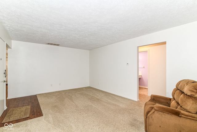 4504 Harvard Dr, Anderson, IN 46013 - carpeted living room featuring a textured ceiling and baseboards