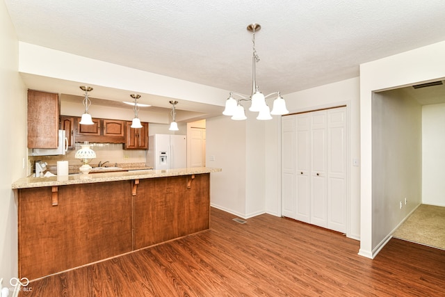 4504 Harvard Dr, Anderson, IN 46013 - kitchen with white appliances, dark wood finished floors, a peninsula, and brown cabinetry