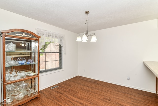 4504 Harvard Dr, Anderson, IN 46013 - unfurnished dining area with a chandelier, wood finished floors, baseboards, and a textured ceiling