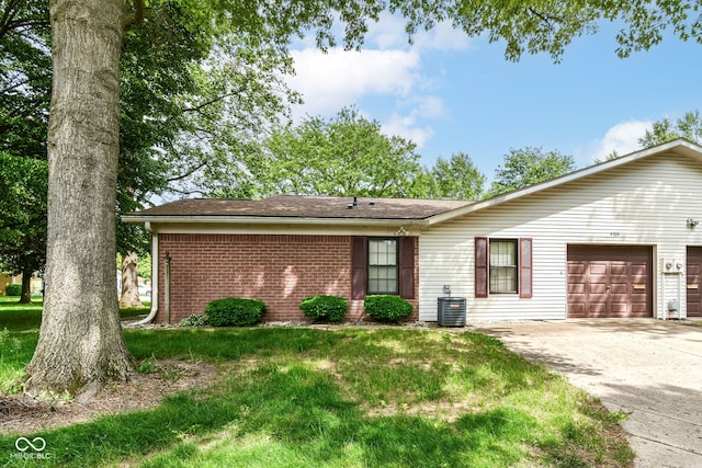 4504 Harvard Dr, Anderson, IN 46013 - ranch-style house with brick siding, an attached garage, concrete driveway, central AC, and a front yard