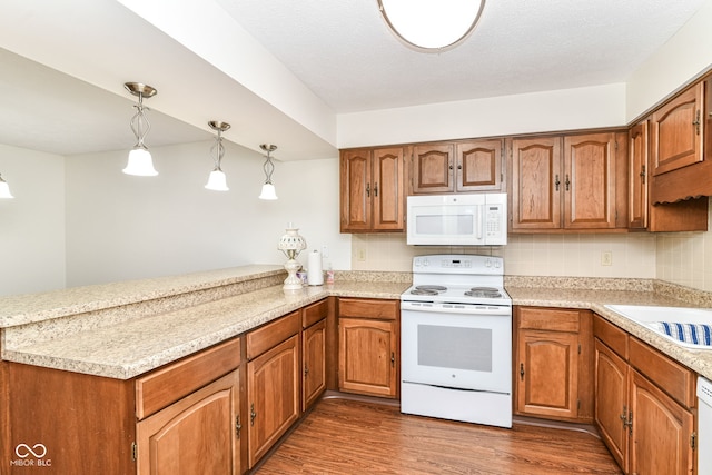4504 Harvard Dr, Anderson, IN 46013 - kitchen with white appliances, a peninsula, light countertops, and wood finished floors
