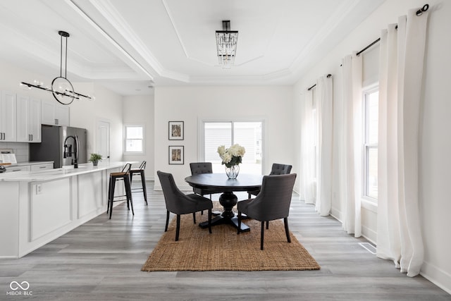 2024 Yandes St, Indianapolis, IN 46202 - dining room featuring a chandelier, a tray ceiling, crown molding, light wood finished floors, and baseboards