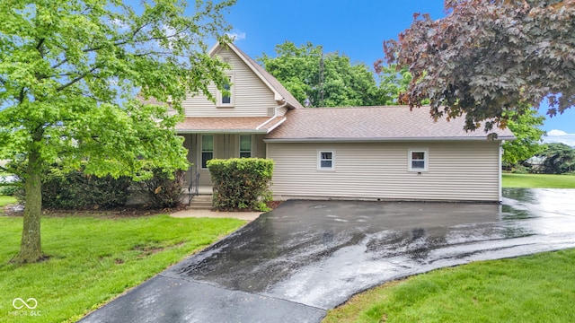 1437 S 725 W, Tipton, IN 46072 - obstructed view of property featuring covered porch, a front yard, and roof with shingles