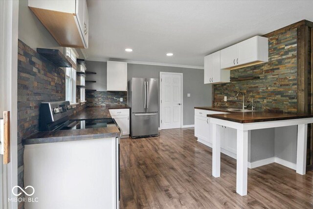 953 W Clinton St, Danville, IN 46122 - kitchen with stainless steel appliances, a sink, dark countertops, tasteful backsplash, and ornamental molding