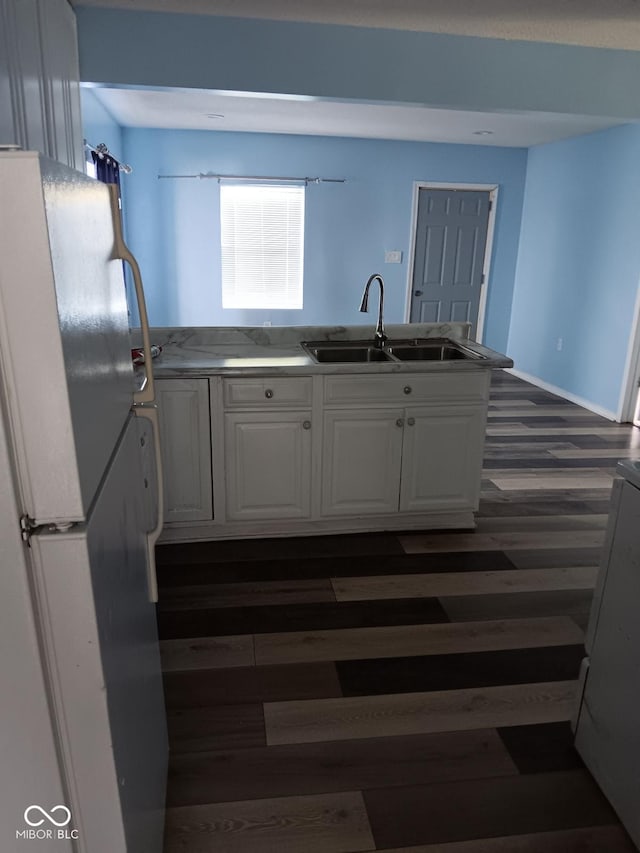 4106 N Pasadena Ave, Indianapolis, IN 46226 - kitchen with freestanding refrigerator, a sink, white cabinetry, and a peninsula