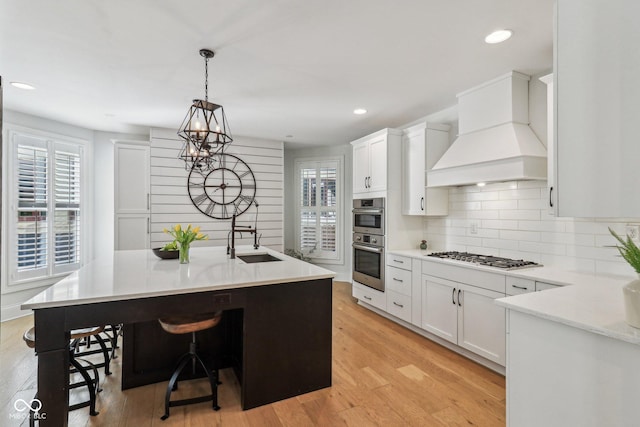 1616 N Delaware St, Indianapolis, IN 46202 - kitchen with gas cooktop, custom range hood, a sink, decorative backsplash, and a kitchen bar