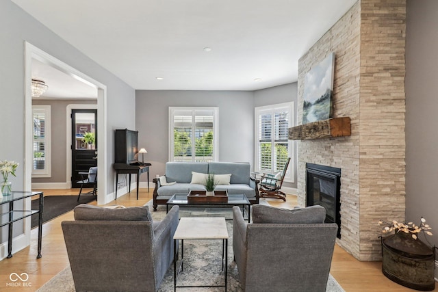 1616 N Delaware St, Indianapolis, IN 46202 - living area featuring a stone fireplace, light wood-type flooring, and baseboards