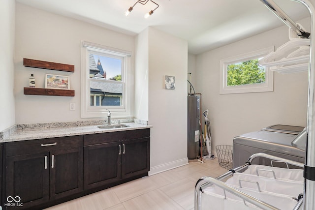 1616 N Delaware St, Indianapolis, IN 46202 - washroom featuring electric water heater, independent washer and dryer, cabinet space, and baseboards