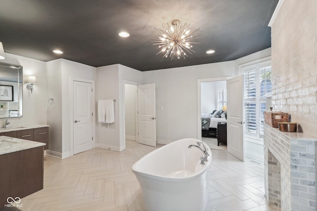 1616 N Delaware St, Indianapolis, IN 46202 - bathroom featuring vanity, a freestanding bath, connected bathroom, baseboards, and a chandelier