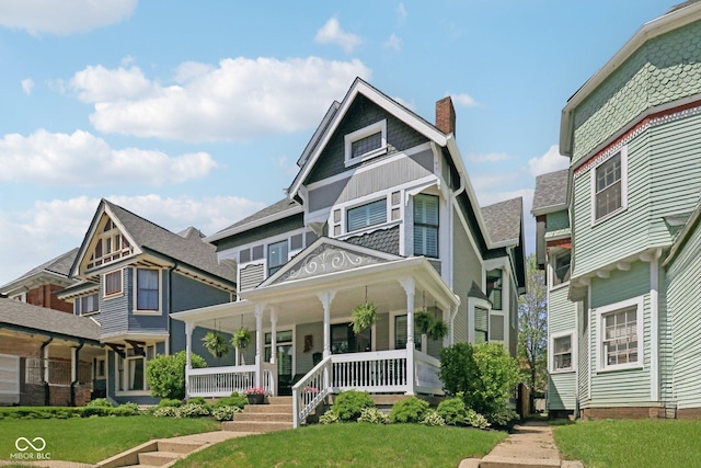 1616 N Delaware St, Indianapolis, IN 46202 - victorian home with a chimney, a porch, a front yard, and roof with shingles