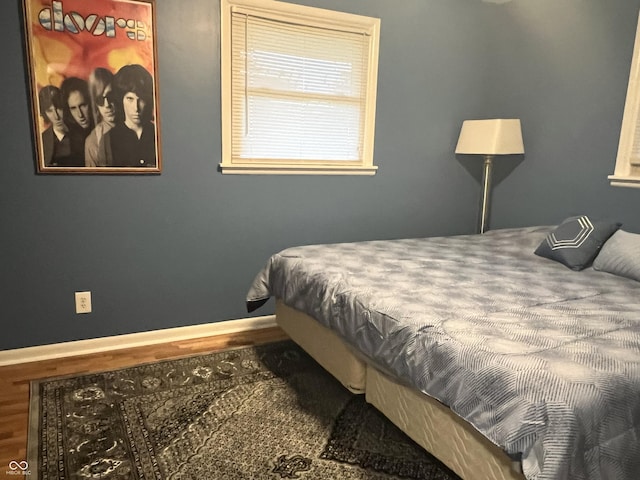 bedroom with baseboards and wood finished floors