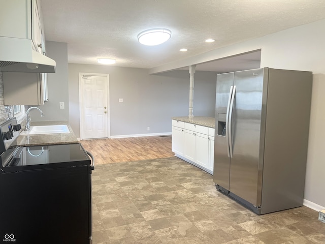 kitchen with stainless steel fridge, a sink, black range with electric stovetop, baseboards, and white cabinetry