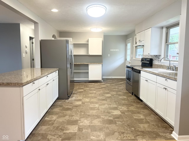 kitchen with a sink, open shelves, appliances with stainless steel finishes, white cabinets, and a textured ceiling