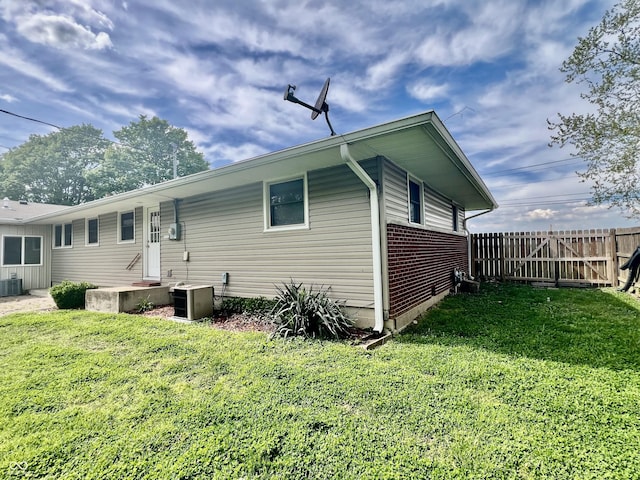 rear view of property with cooling unit and brick siding