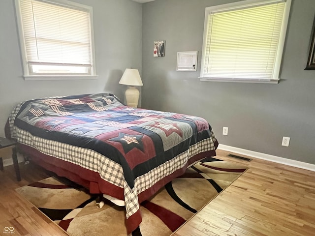bedroom featuring wood finished floors and baseboards